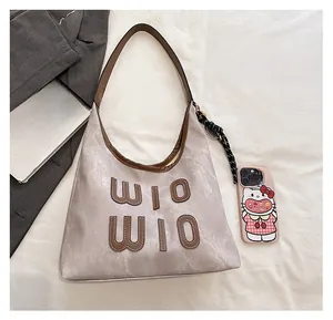 Hobo bag detail showing large capacity, brown letter logo, and woven rope ornament