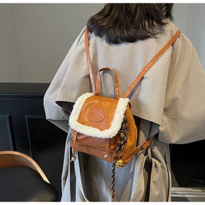 Vue détaillée d'un mini sac à dos en cuir camel avec bordure en fourrure sur mannequin