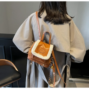 Detail of tan faux leather backpack with white faux shearling trim and FASHION logo
