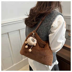 Detail of plush brown faux fur shoulder bag with a cute white sheep charm