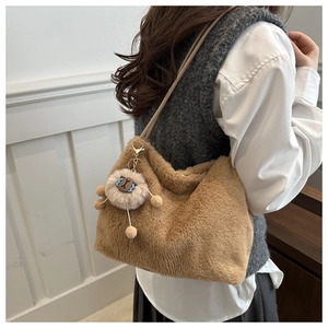 Close-up of fluffy plush shoulder bag in brown with a cute lion charm accessory