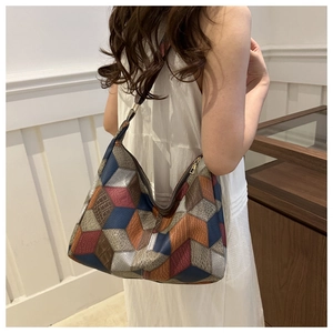 Detail view of the geometric 3D pattern and multi-textured patchwork on the tote bag