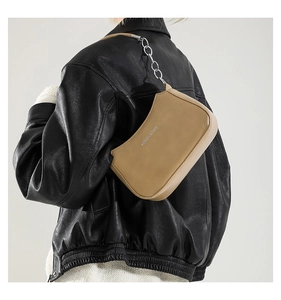 Detail of khaki crescent underarm bag with silver chain strap and fashion text logo