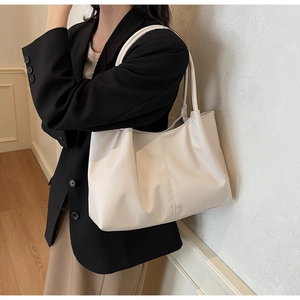 Close-up of cream white tote bag with vertical stitching and smooth leather texture