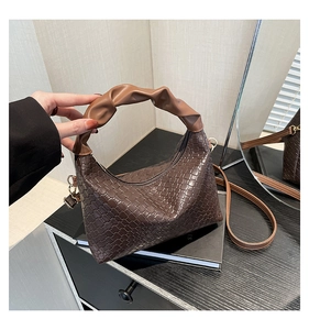 Detail of dark brown woven texture hobo bag with a light brown scrunchie handle