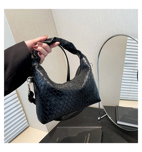 Close-up of black crossbody dumpling bag featuring textured faux leather and cloud handle