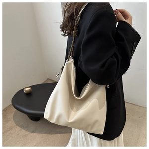 Detail of soft cream-white hobo bag with unique dark brown knotted shoulder strap