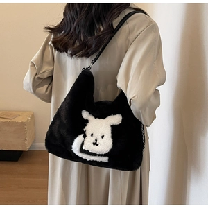 Detail of black plush tote bag featuring a cute white rabbit pattern and silver metal chain