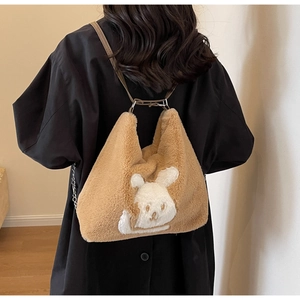 Close-up of brown plush tote bag featuring a cute white rabbit patch and slim handles