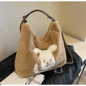Detail of plush brown tote bag featuring rabbit patch, faux fur texture and chain strap