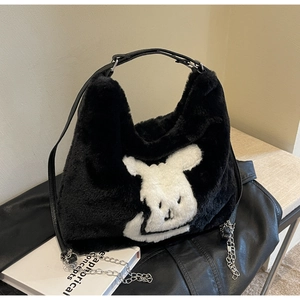 Detail of black faux fur tote bag featuring a white cartoon pattern and chain strap