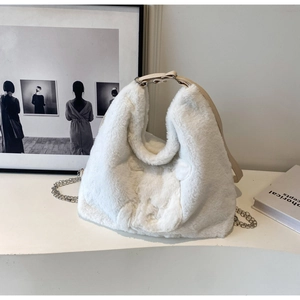 Detail of white plush faux fur tote bag with leather strap and silver chain accent