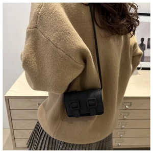 Rear view of a black mini square crossbody bag on model with vintage matte finish straps
