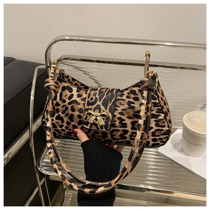 Detail of leopard print bag featuring gold butterfly buckle and knotted shoulder strap