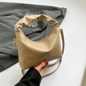 Beige woven leather crossbody bag with pleated scrunchie handle and adjustable strap