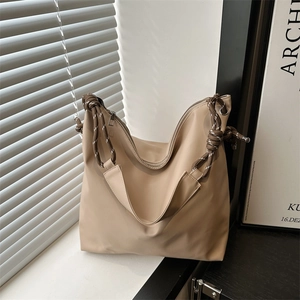 Minimalist beige tote bag with wide braided rope shoulder straps and a spacious soft design