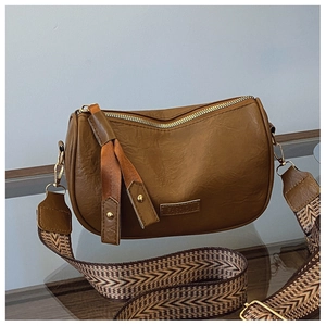 Detail of vintage brown shoulder bag with wide ethnic pattern woven strap on glass