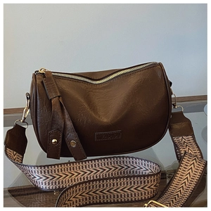Detailed macro of vintage dark brown leather crossbody bag with ethnic patterned strap