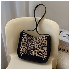 Detail of leopard print shoulder bag with black leather trim on a stylish chair