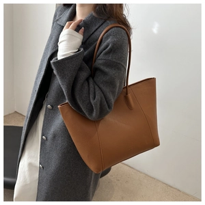 Détail du sac cabas en cuir marron avec texture grainée et grande capacité de rangement