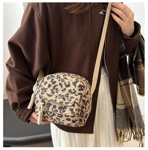 Detail of corduroy leopard print square bag with beige strap and fabric texture