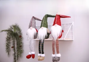 Detailed view of three long-legged Christmas gnomes in grey green and red festive colors
