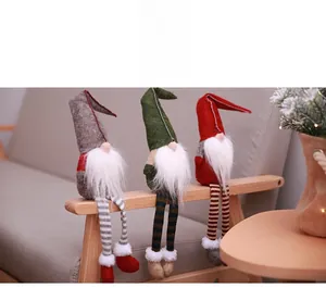 Detailed view of three faceless Christmas gnomes with long striped legs on wooden surface