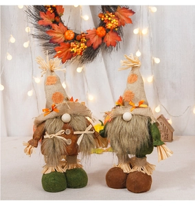 Detail of harvest gnome dolls with maple leaves and pumpkins in a warm home setting