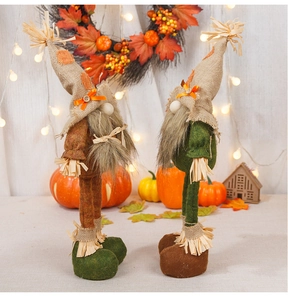Close-up of harvest gnomes with autumn maple leaves and rustic burlap textures