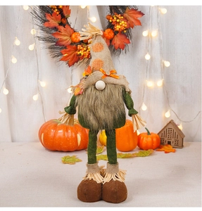 Detail of harvest gnome figurine featuring maple leaf decorations and telescopic long legs