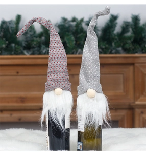 Close-up of Nordic knitted gnome wine bottle covers with grey star patterns and white beards