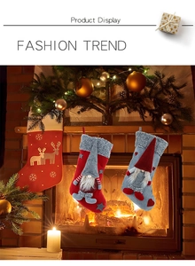 Detail of red and grey gnome Christmas stockings with plush cuffs near a warm fireplace