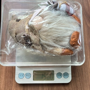 Mesure du poids d'une figurine de gnome en peluche avec une longue barbe blanche