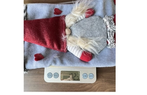 Detailed top view of a large Christmas gnome stocking gift bag weighing 102g on a scale