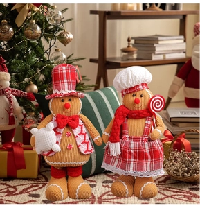 Detail of plush gingerbread chef couple figurines in red and white plaid festive outfits