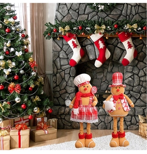 Cozy Christmas gingerbread couple dolls standing on white fur carpet by a fireplace