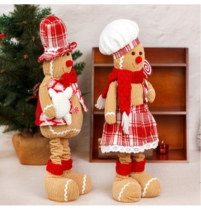 Detail of plush gingerbread couple dolls in festive red plaid and corduroy outfits