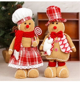 Detail of plush gingerbread couple dolls in corduroy outfits with festive Christmas decor
