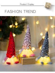 Detail of three sequined Christmas gnomes with glowing beards on wooden stand