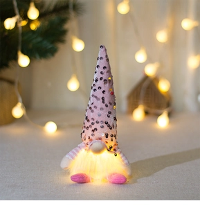 Close-up of a pink sequined Christmas gnome with LED glowing light and plush details