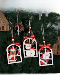 Detail of wooden Christmas window ornaments with Santa and snowman on pine branches