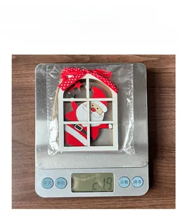 Macro shot of a wooden Santa Claus window ornament being weighed on a scale