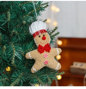 Gingerbread man ornament with chef hat on Christmas tree with warm bokeh lighting
