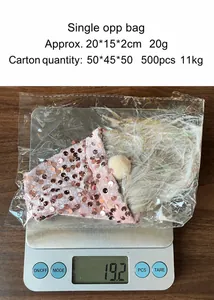 Detail einer Weihnachtszwerg-Weinflaschenhülle mit Pailletten auf einer Waage bei 19,2g