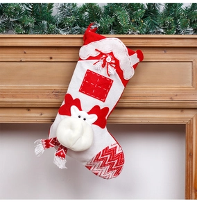 Detail of red and white knit Christmas stocking with 3D reindeer head on a wooden mantel