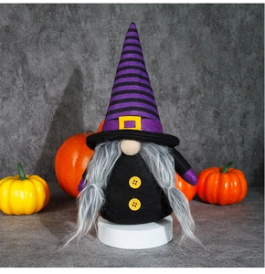 Detail of Halloween gnome plush toy with purple striped hat and yellow buckle on a white stand