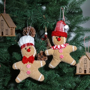 Christmas gingerbread man plush ornaments with hats and scarves hanging on a festive tree