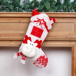 Red and white knitted Christmas stocking decoration with reindeer antlers on a mantel