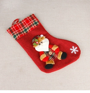 Detail of red linen Christmas stocking with 3D Santa doll and green plaid cuff