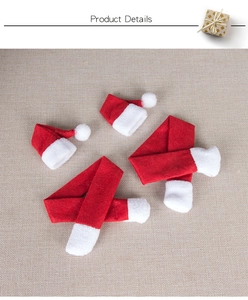 Close-up of mini Christmas hats and striped scarves on linen, festive bottle decor